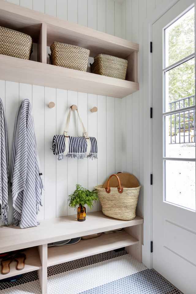 lake house entryway with shiplap walls, cubbies and penny tile flooring